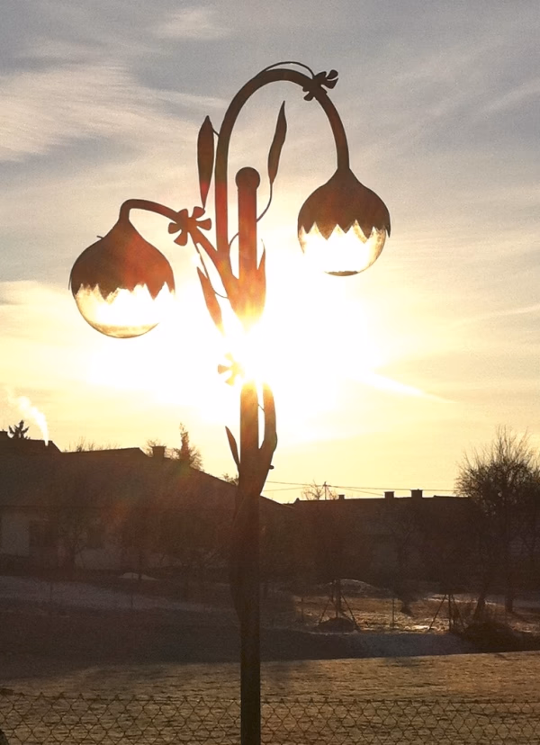 Blumenförmige Außenleuchte bei tief stehender Sonne