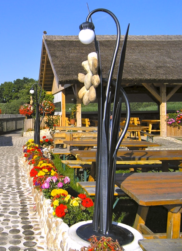 Steinblumen mit einer gebogenen Gartenleuchte